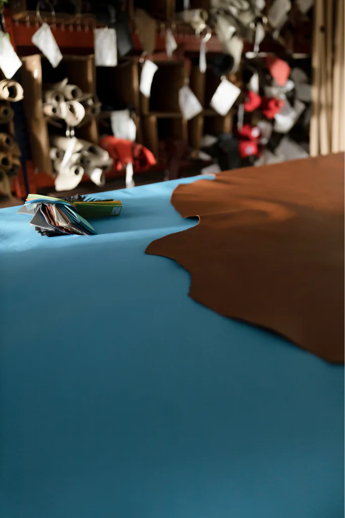 Blue and brown leather laid out on a table in the Kravczyk workshop